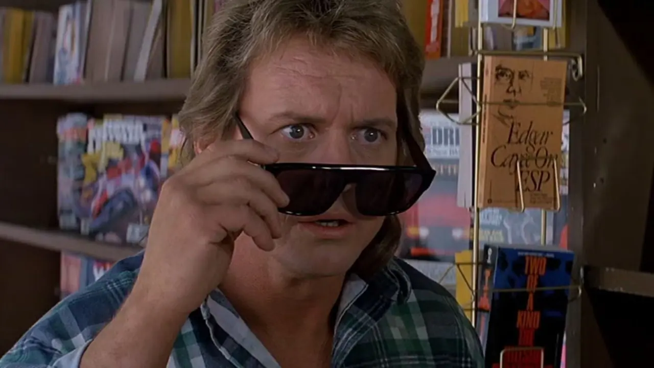 Roddy Piper mientras Nada mira más allá de sus gafas en They Live Roddy Piper mientras Nada mira más allá de sus gafas en They Live