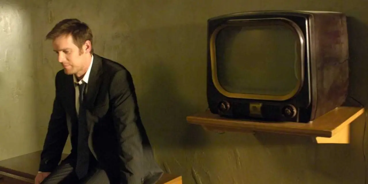 Joe Miller sitter ensam i The Lost Room bredvid en gammal TV