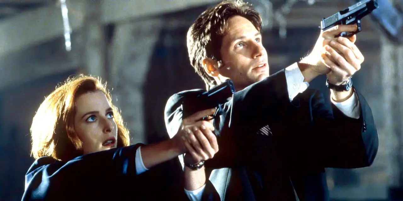 Mulder y Scully apuntan con sus armas hacia algo en The X-Files