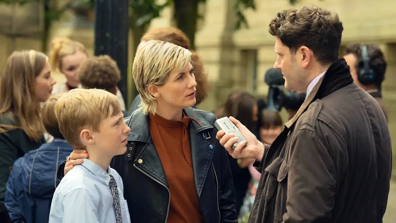 Toxic Town nadal przedstawia Jodie Whittaker w roli Susan McIntyre rozmawiającej z reporterem z synem. Toxic Town nadal przedstawia Jodie Whittaker w roli Susan McIntyre rozmawiającej z reporterem z synem.
