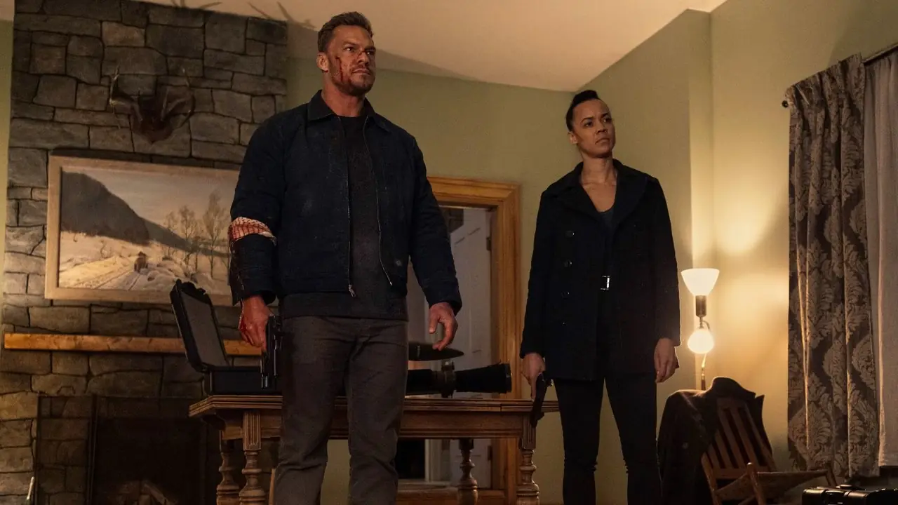 Reacher (Alan Ritchson) وNeagley (Maria Sten) يقفان معًا داخل منزل في Reacher