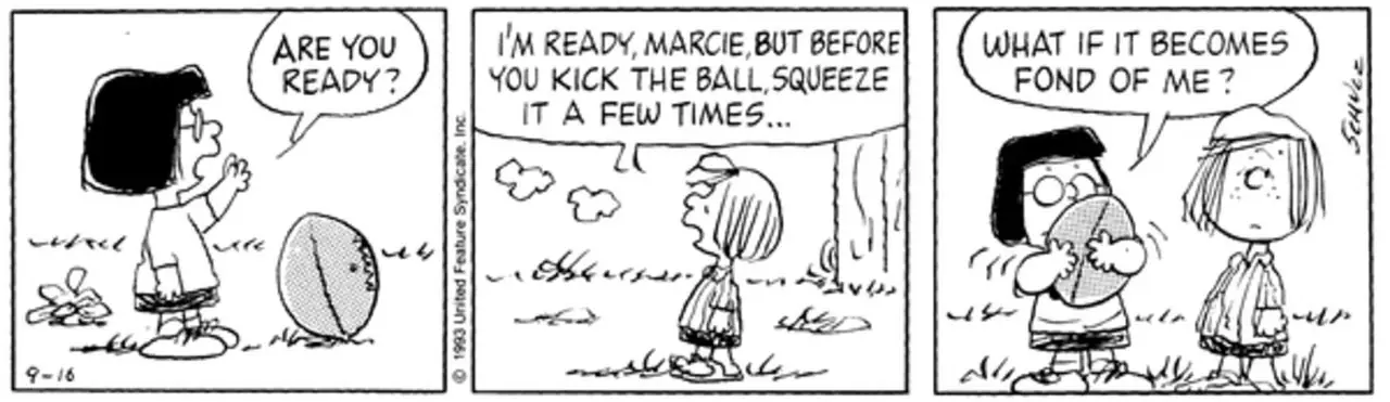 Marcie apretando una pelota de fútbol mientras Peppermint Patty observa.