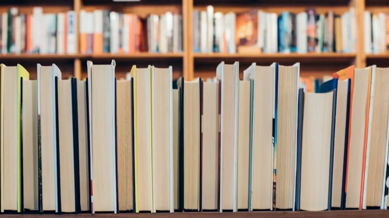 Livres empilés devant une étagère