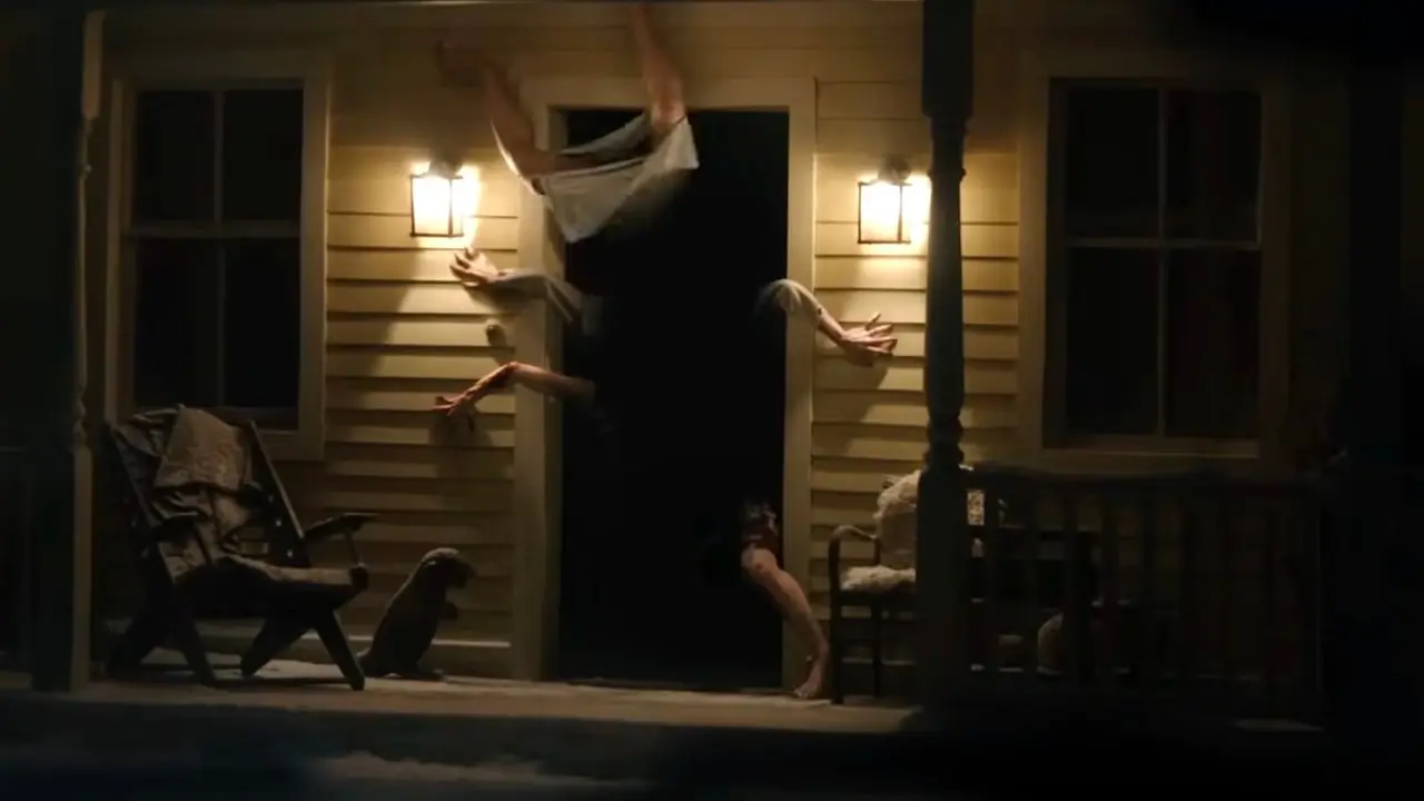 Un monstruo de muchas extremidades emerge de una puerta oscura en el tráiler de Resident Evil 2026