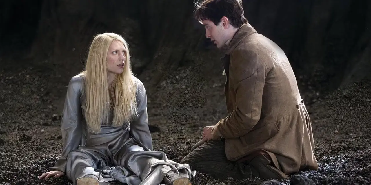 Yvaine (Claire Danes) em um vestido prateado com Tristan Thorn (Charlie Cox), ambos no chão se olhando com ceticismo em Stardust.