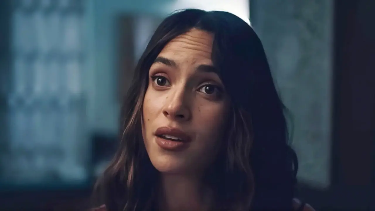 Adria Arjona luce una expresión seria en una escena de Splitsville