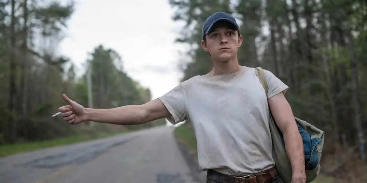 Tom Holland podróżujący autostopem i palący papierosa w „Diabeł cały czas”.