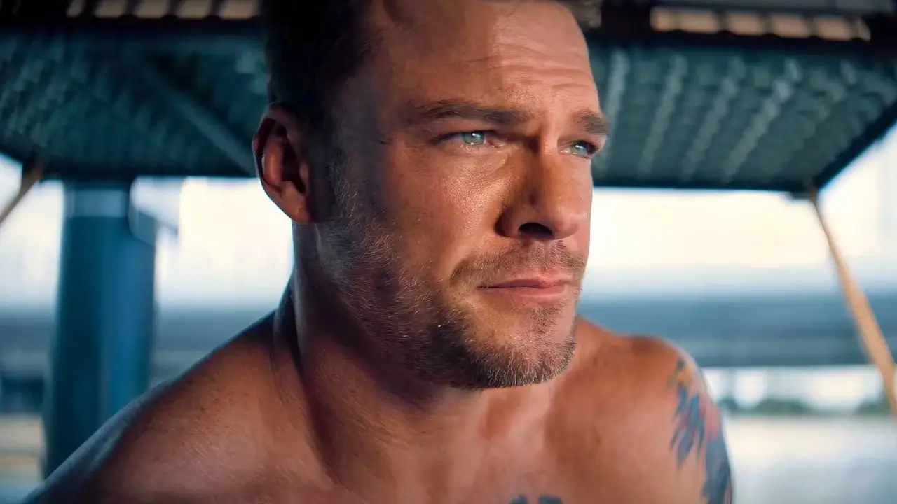 Alan Ritchson parece emocionado ao olhar para o mar em Runner