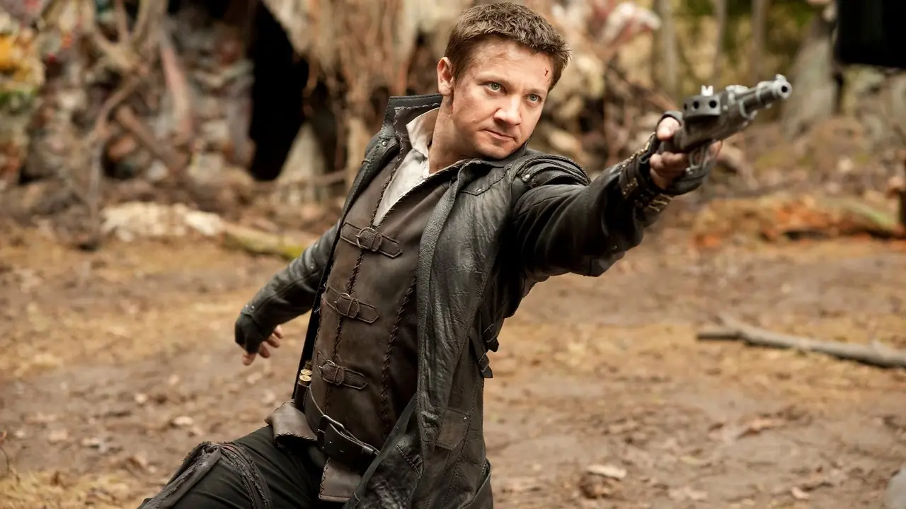 Hansel de Jeremy Renner pointant son arme à genoux dans Hansel & Gretel : Witch Hunters
