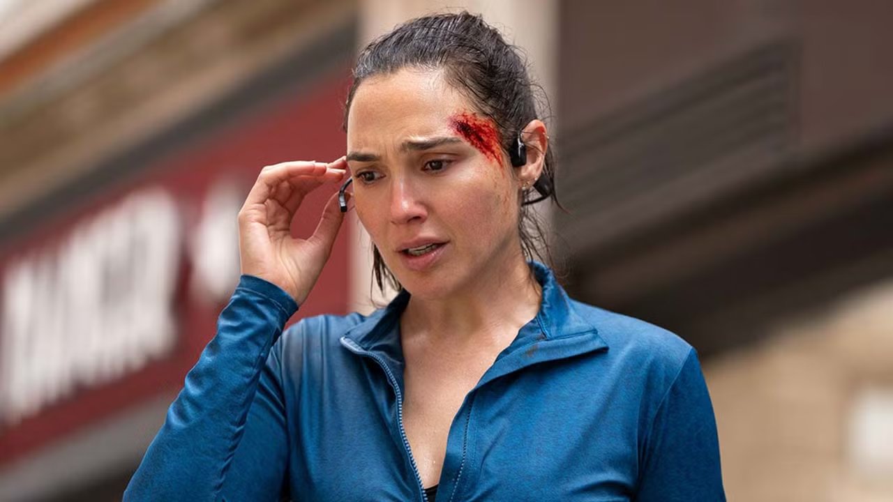 Maia de Gal Gadot parece preocupada mientras se lleva los auriculares a la oreja en The Runner YT