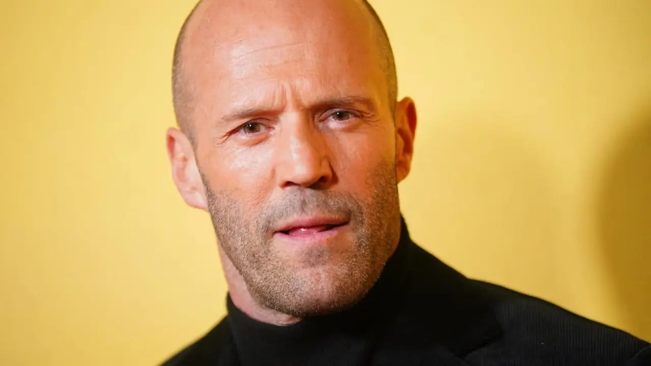 Jason Statham posando frente a una pared colorida Jason Statham posando frente a una pared colorida
