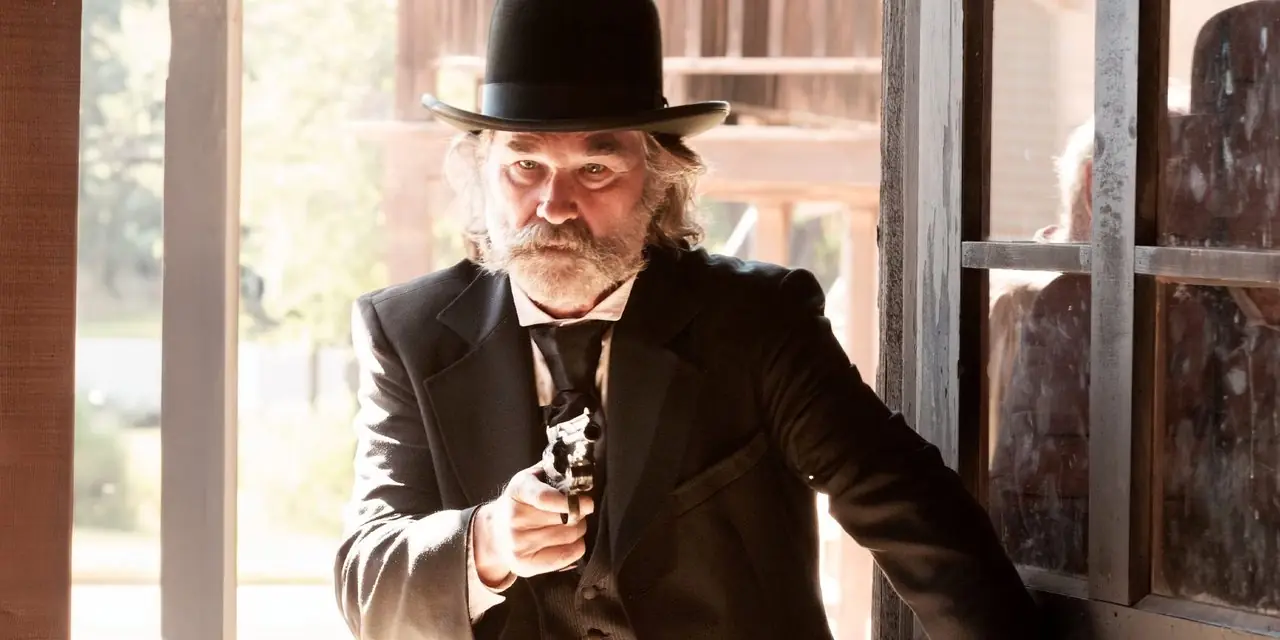 Kurt Russell wchodzi do budynku, celując z broni w scenie z filmu Bone Tomahawk