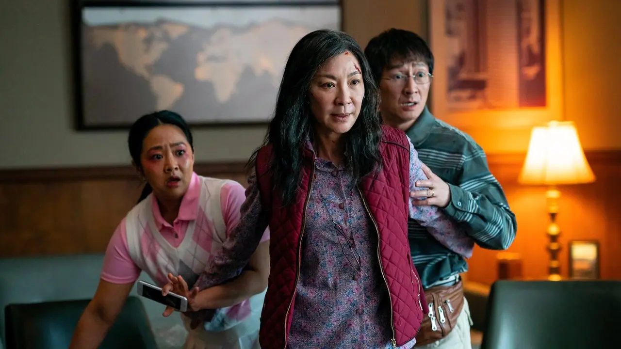 Evelyn Wang lève les bras devant Joy et Waymon dans Everything Everywhere All at Once.