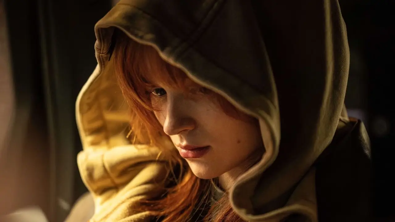 Jean Grey portant sa capuche relevée et assise à l'arrière d'une voiture