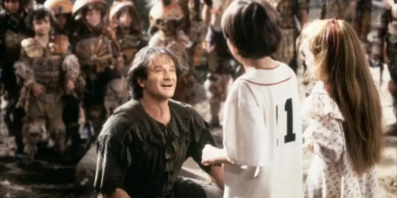 Peter kneler ned for barna sine med et smil om munnen foran Lost Boys i filmen Hook.