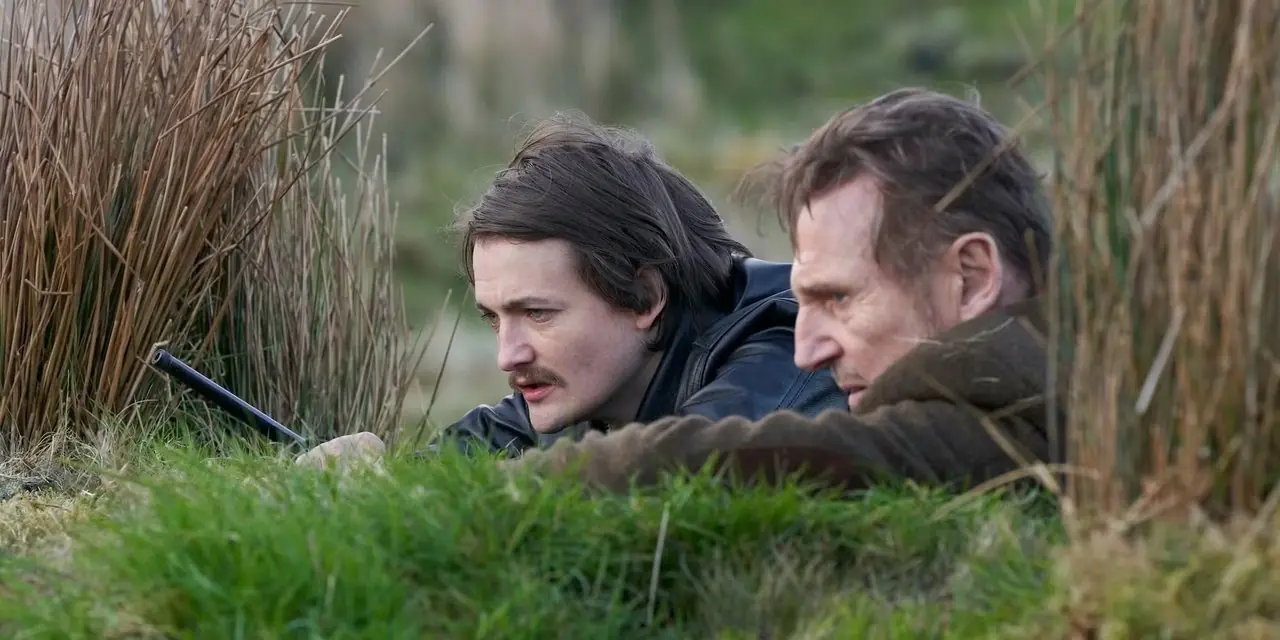 Jack Gleeson y Liam Neeson encorvados en la hierba en En la tierra de los santos y los pecadores-2