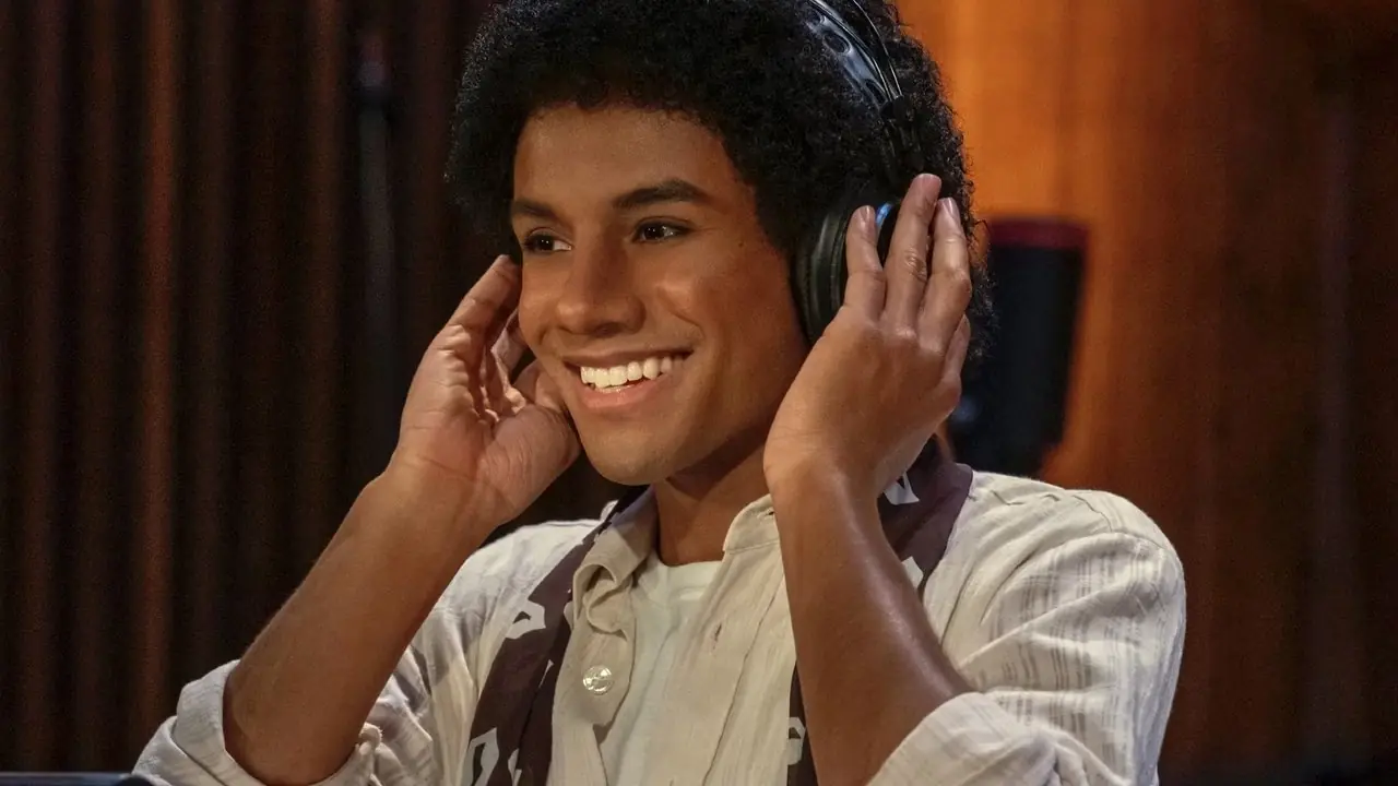 Jaafar Jackson jako Michael Jackson uśmiecha się w słuchawkach w Michael 2026