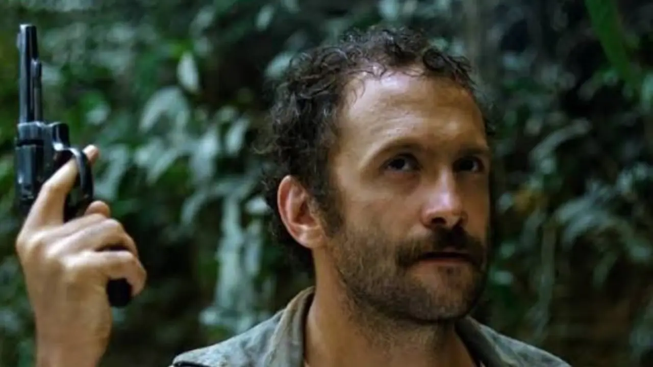 Un hombre sostiene una pistola en Cannibal Holocaust
