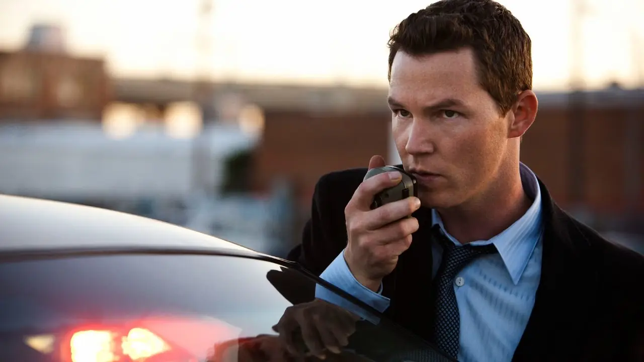 Shawn Hatosy, Southland'da polis arabasının önünde dururken telsizle konuşuyor