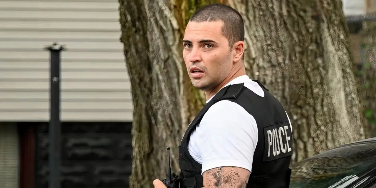 Benjamin Levy Aguilar als Dante Torres in seizoen 12 van de politie van Chicago, staande tegen een boom en op zoek naar iemand