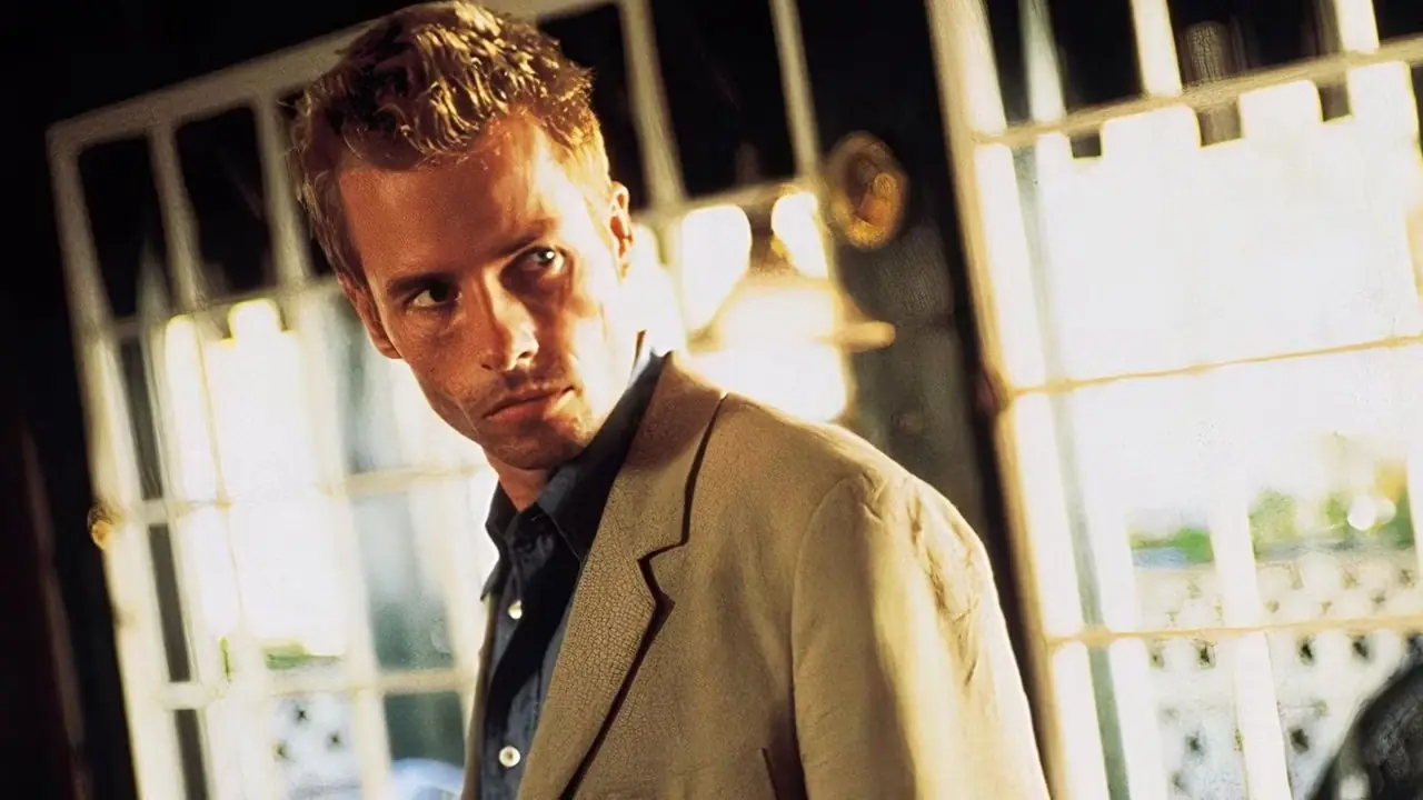 Guy Pearce mira detrás de él como Leonard en Memento