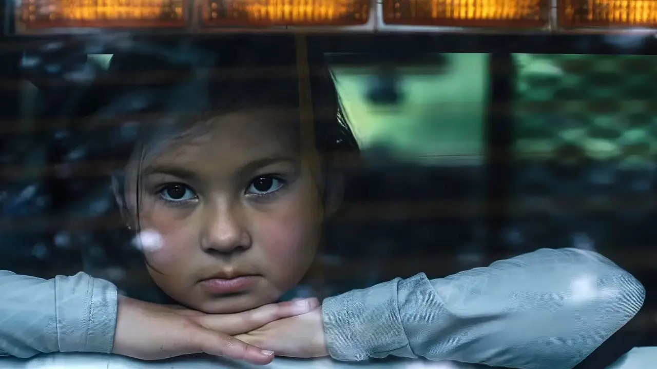 Josephine apoiando a cabeça nas mãos e olhando pela janela traseira de um carro
