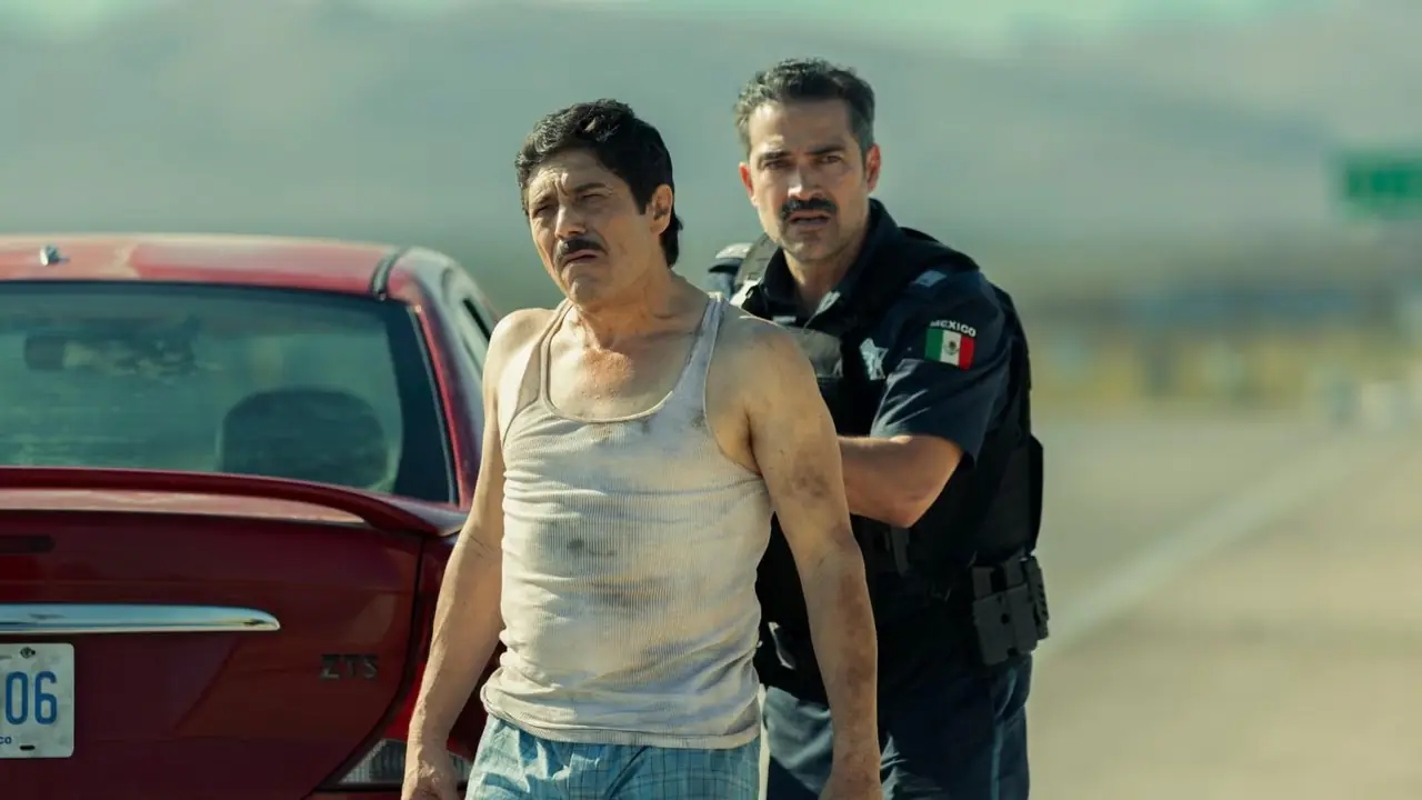 El Chapo'yla Yüzleşmek'te El Chapo'nun arkasında bir polis memuru duruyor