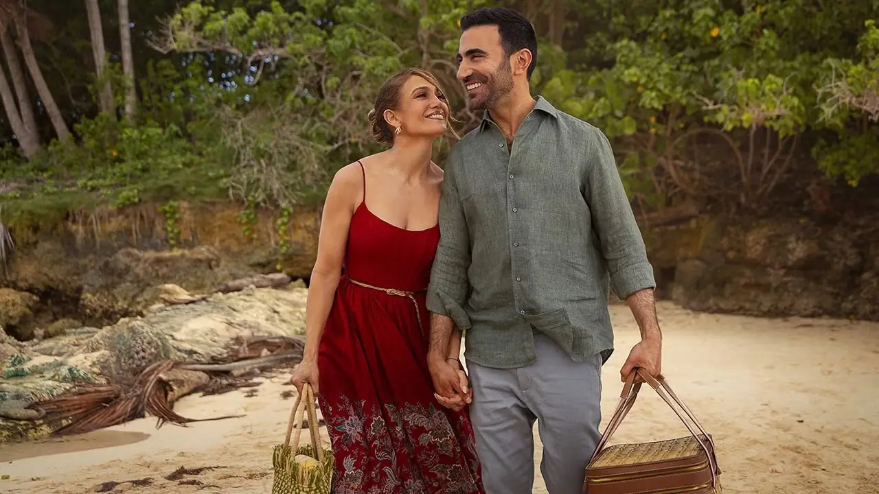 Jackie von Jennifer Lopez und Daniel von Brett Goldstein lächeln und halten Händchen, während sie in Office Romance YT am Strand spazieren gehen Jackie von Jennifer Lopez und Daniel von Brett Goldstein lächeln und halten Händchen, während sie in Office Romance YT am Strand spazieren gehen