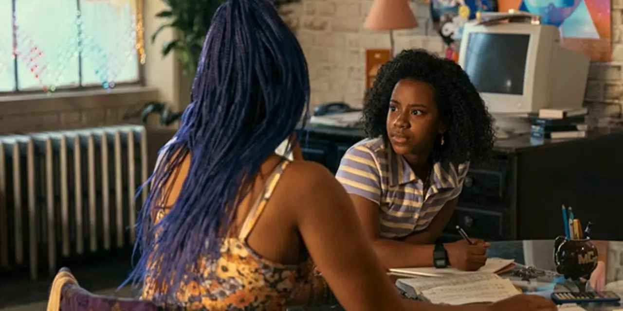 Tiffany adulta y joven sentadas juntas en una mesa en Paper Girls