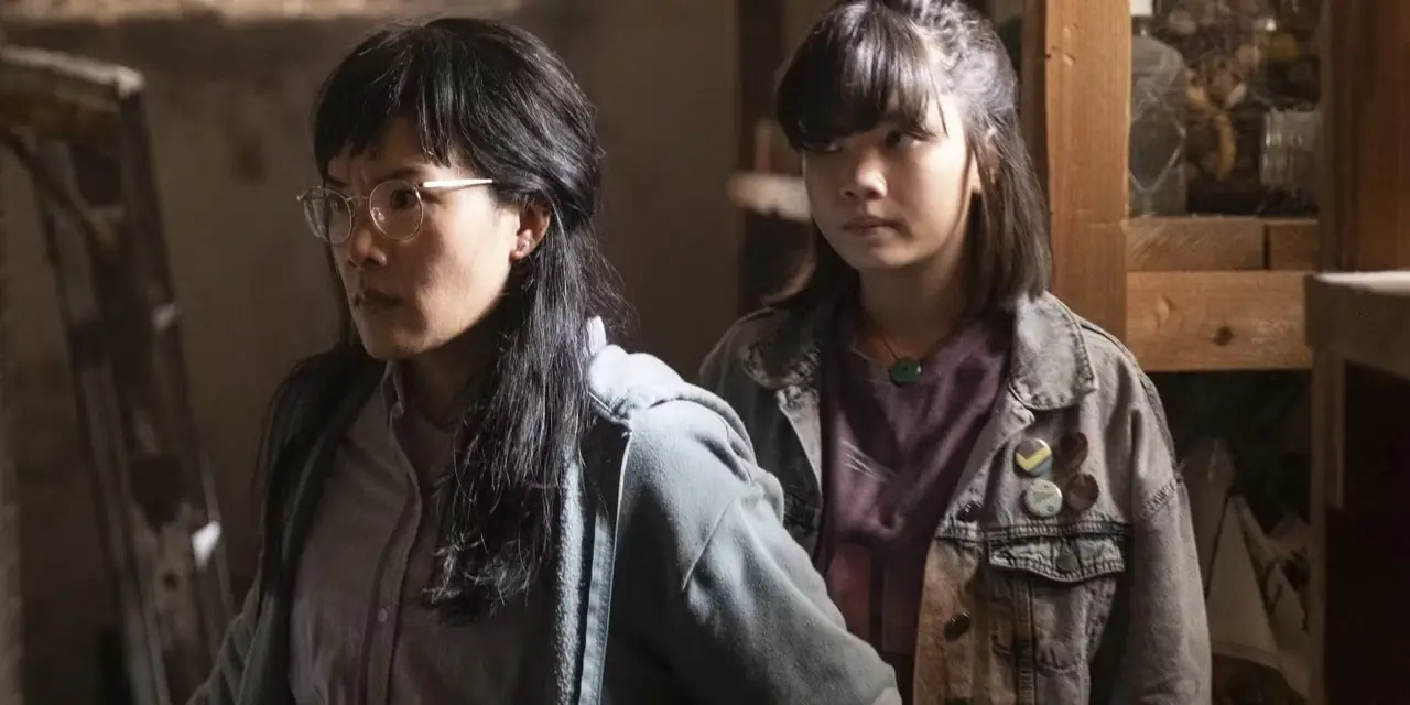 Erin adulta y joven paradas juntas luciendo serias en Paper Girls