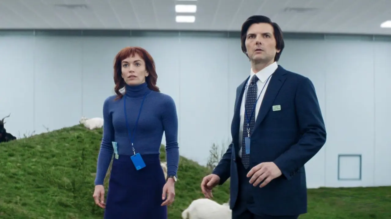 Britt Lower como Helly y Adam Scott como Mark mirando hacia arriba mientras está parado frente a las cabras en la temporada 2 de Severance.