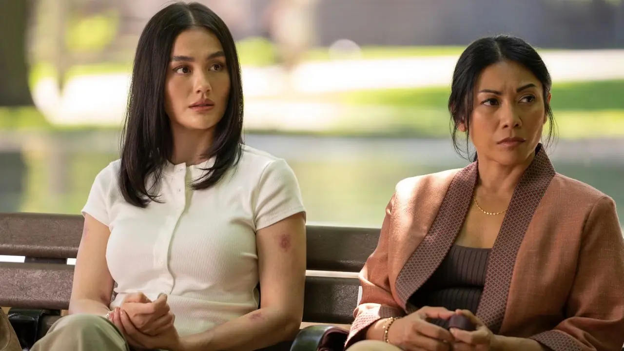 Agnez Mo nei panni di Lilo Hoth e Anggun nei panni di Amisha Hoth seduti su una panchina nella stagione 4 di Reacher Agnez Mo nei panni di Lilo Hoth e Anggun nei panni di Amisha Hoth seduti su una panchina nella stagione 4 di Reacher