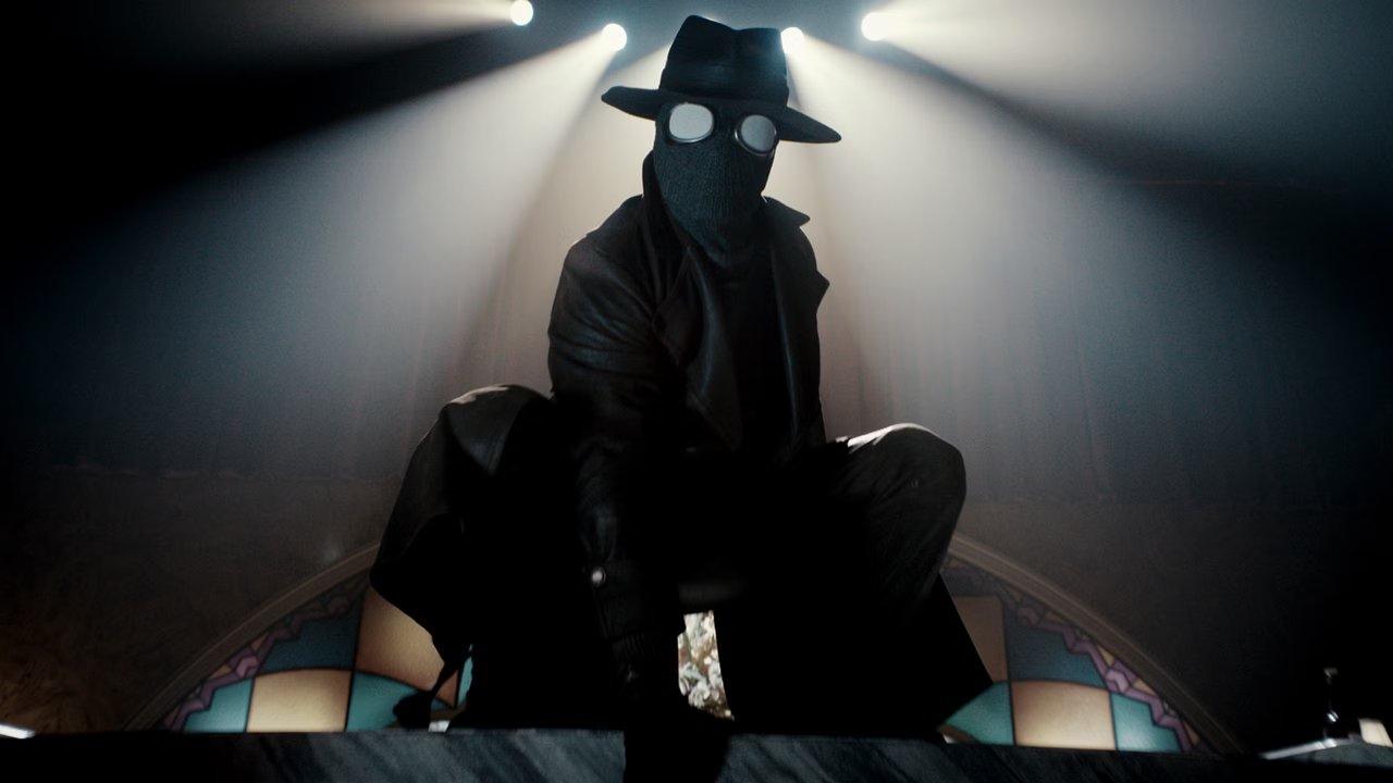 Spider-Noir fortfarande med Nicolas Cage som Ben Reilly/Spindeln, hukande med ljus som flödar in bakom honom. Spider-Noir fortfarande med Nicolas Cage som Ben Reilly/Spindeln, hukande med ljus som flödar in bakom honom.