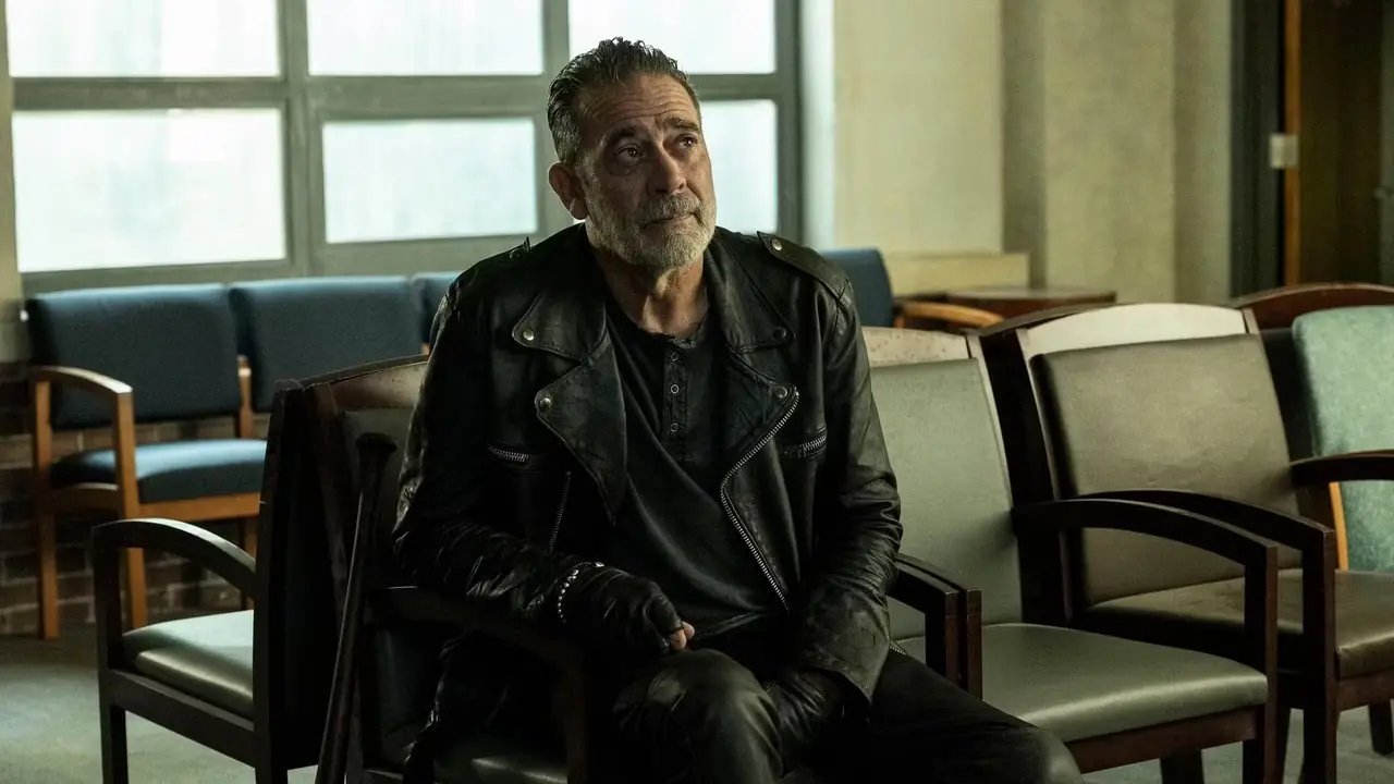 Jeffrey Dean Morgan als Negan, der in The Walking Dead: Dead City auf einem Stuhl sitzt und verärgert aussieht Jeffrey Dean Morgan als Negan, der in The Walking Dead: Dead City auf einem Stuhl sitzt und verärgert aussieht