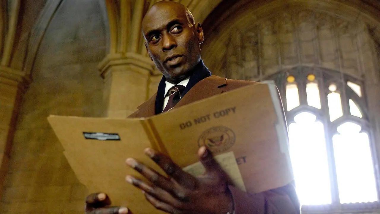 De Broyles van Lance Reddick zien er verdacht uit terwijl ze een bestandsmap in Fringe vasthouden