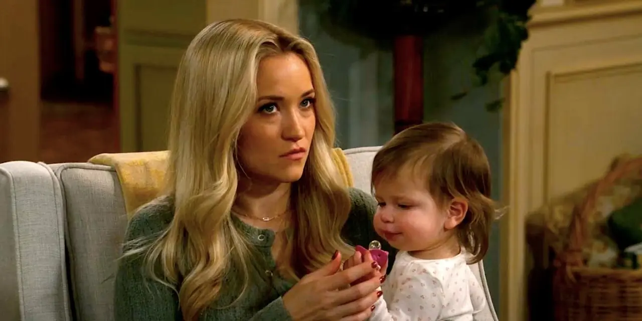 Mandy di Emily Osment tiene in braccio la sua piccola CeeCee e sembra sospettosa seduta su un divano nell'episodio 13 del primo matrimonio di Georgie e Mandy