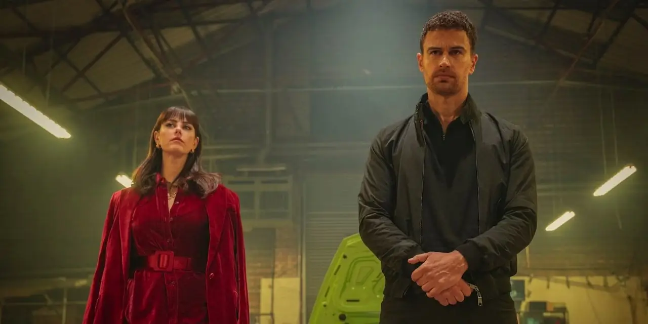 Kaya Scodelario som Susie og Theo James som Eddie står sammen i en hangar i The Gentlemen-serien