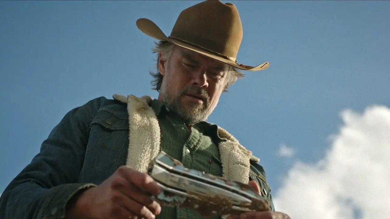 Josh Duhamel regarde quelque chose dans sa main dans Ransom Canyon