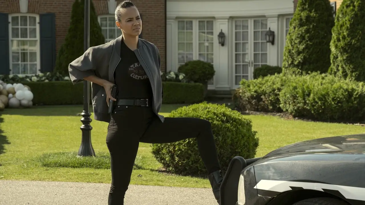 Maria Sten dans le rôle de Neagley avec ses mains sur ses hanches et son pied sur une voiture dans Reacher