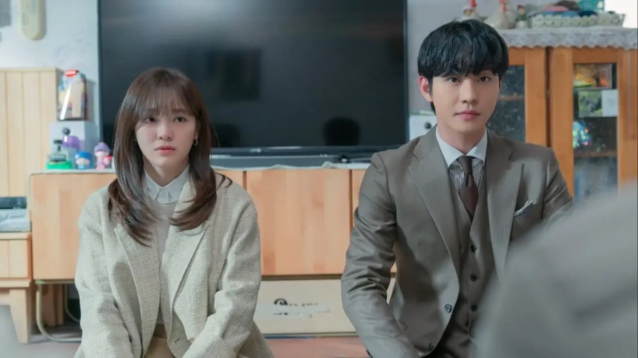 İş Teklifi K-dramasında yan yana diz çöken genç bir kadın ve genç bir adam İş Teklifi K-dramasında yan yana diz çöken genç bir kadın ve genç bir adam